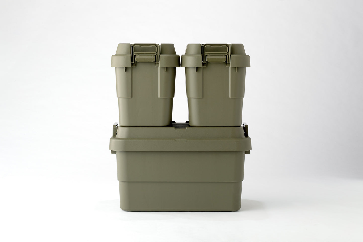 Two green TRUNK CARGO 20L plastic storage boxes stacking on a green TRUNK CARGO 50L plastic storage box